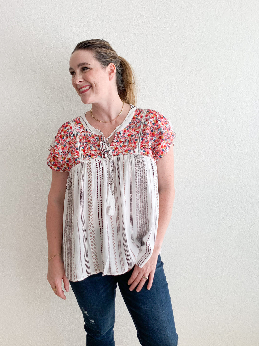woman wearing flowy top with embroidery